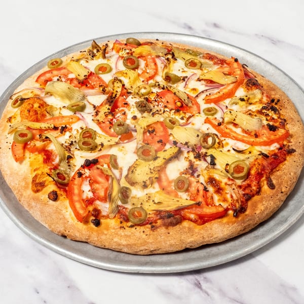 Ristorante da Maria's Italian pizza with tomatoes, artichokes, olives, and red onions on a metal pan.